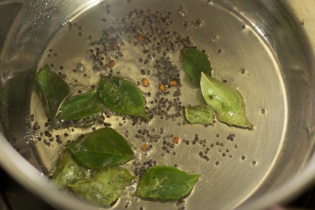 Add curry leaves to the pot to make Bendakaya curry. 