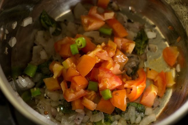 Add chopped tomatoes and chopped green chillies to the pan. 