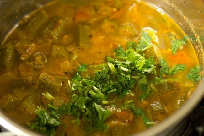 Add chopped coriander leaves to the cooked Bendakaya Pulusu. 