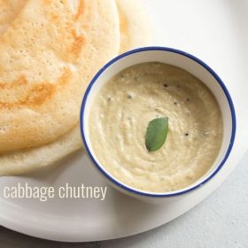 cabbage chutney with a curry leaf in center in a blue rimmed white bowl with dosa on the side in a white plate