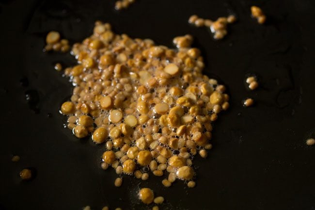 lentils golden in oil in black pan