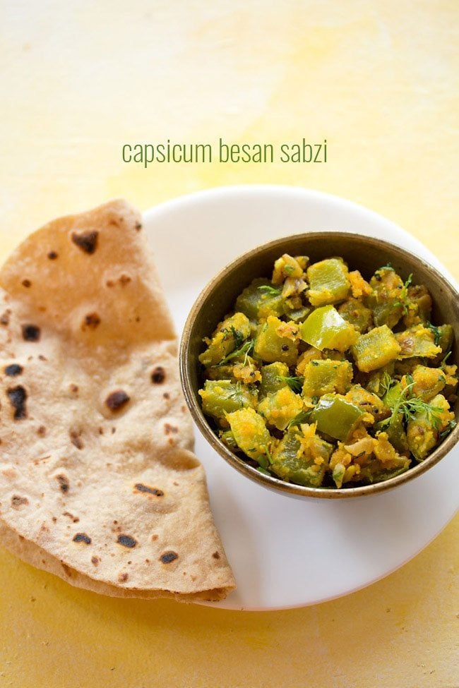 capsicum besan bhaji served in a bowl with chapatti placed on a plate and text layover.