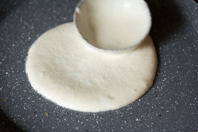 pouring ladleful of batter on a pan. 