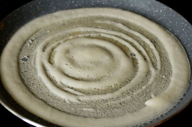 cooking dosa on the pan. 