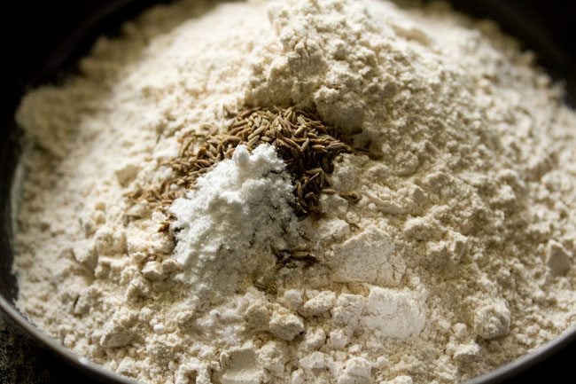 Place whole wheat flour, ground cumin seeds, baking powder and salt in a bowl. 