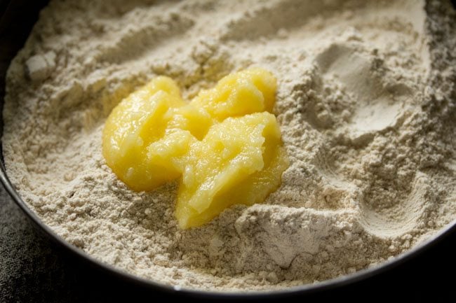 Add ghee to flour mixture.