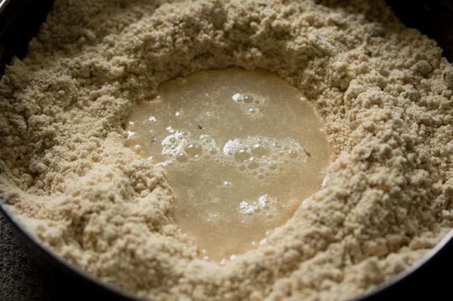 Add the first portion of water to the flour mixture.