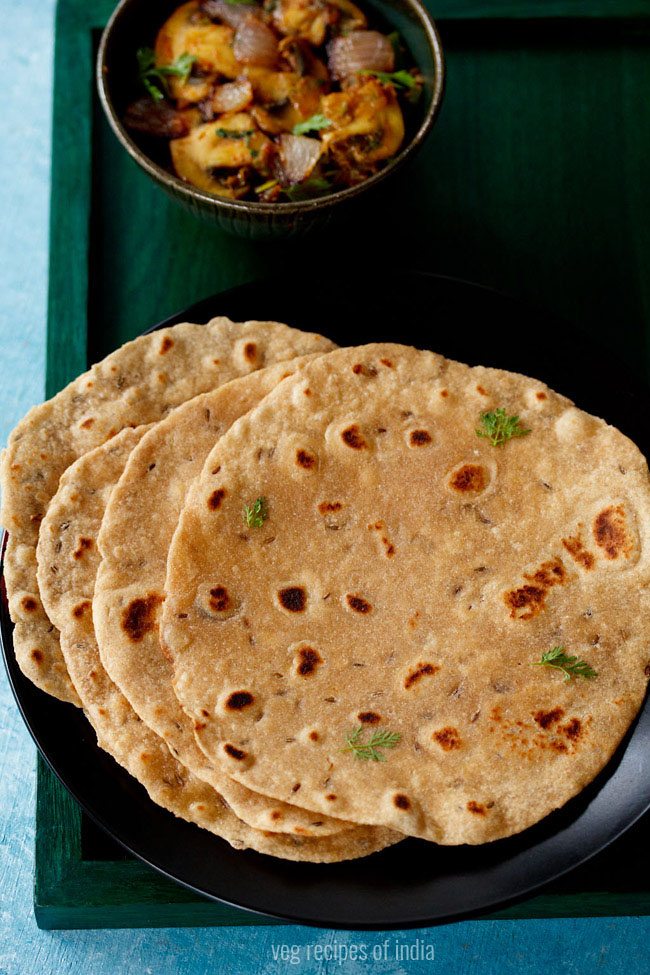 khasta roti served on a black plate with a bowl of vegetable dish kept on the top side and text layover. 