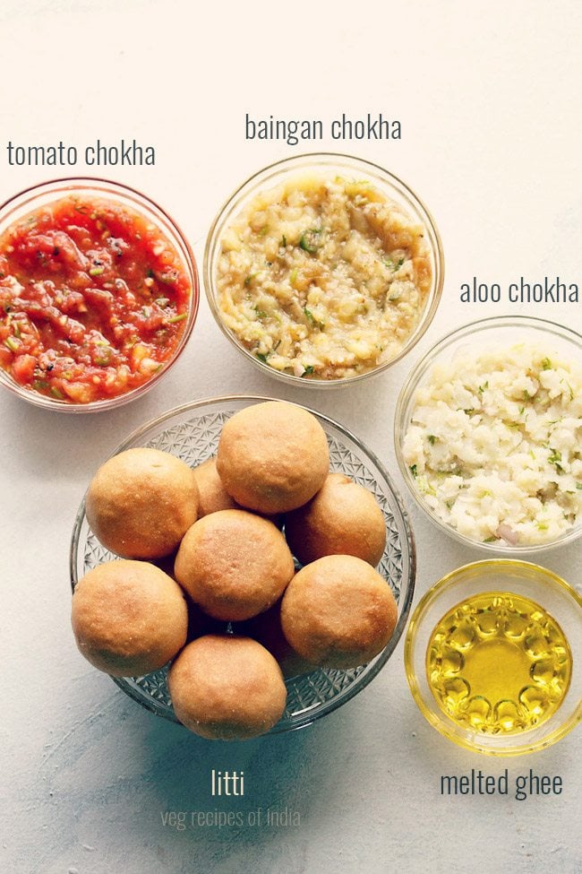 litti chokha served in glass bowls with a small bowl of ghee and text layover. 