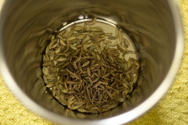 cumin seeds and fennel seeds added to a mortar for making stuffing for litti 