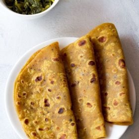 masala paratha served on a white plate with a side of dry veggie dish