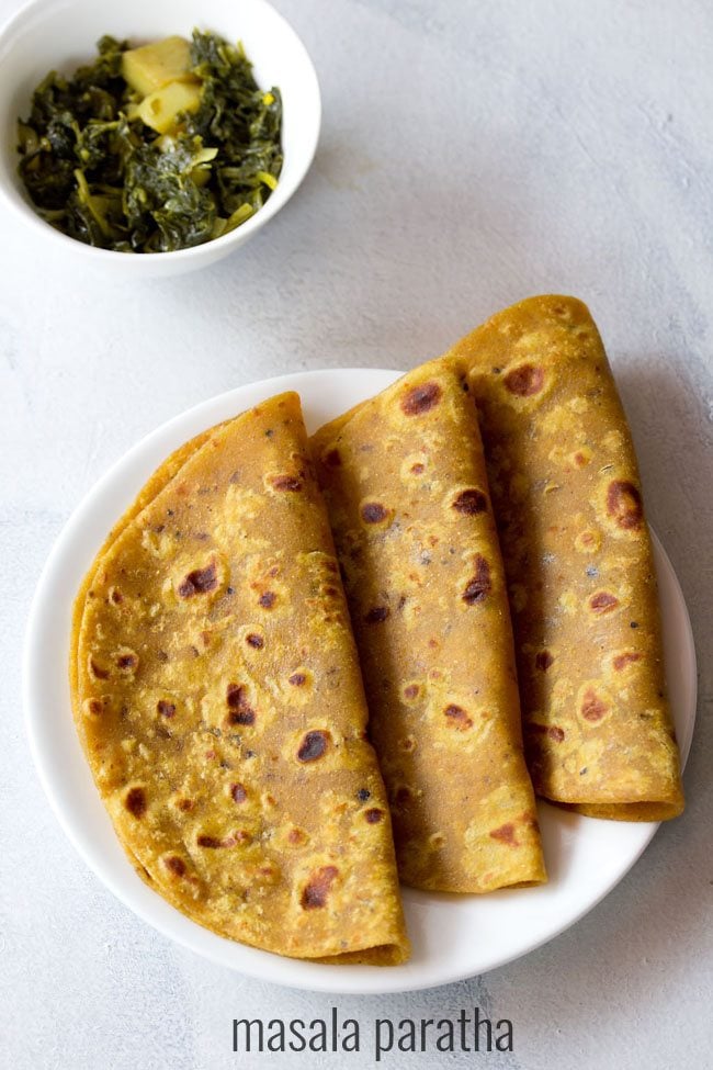 masala paratha served on a white plate with a side of dry veggie dish