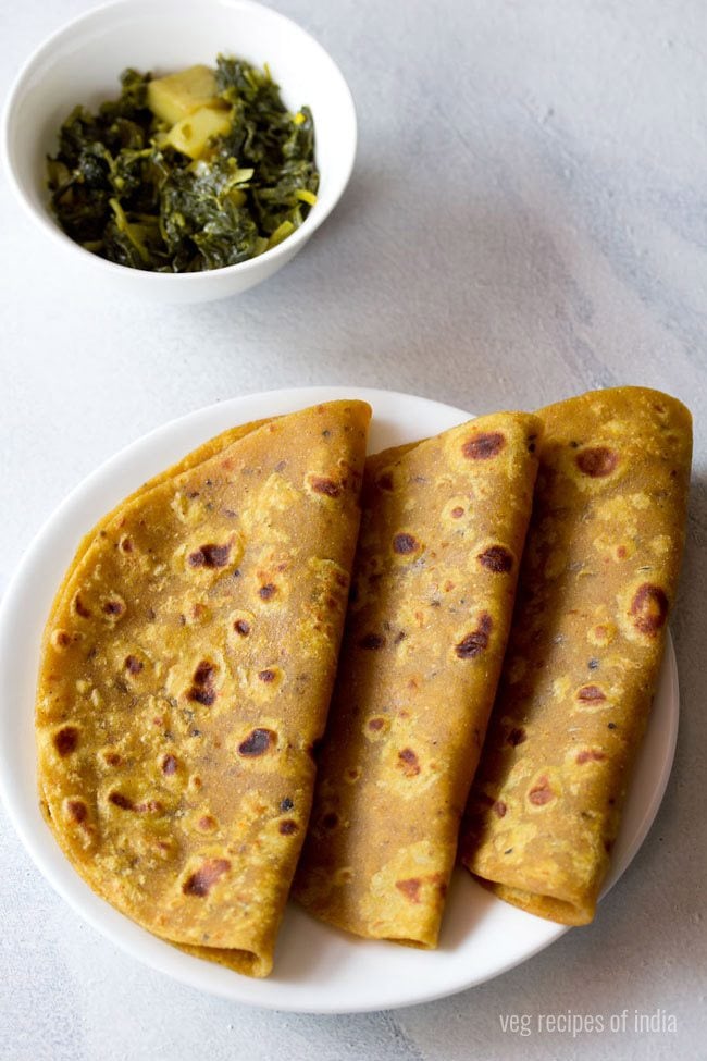 masala paratha served on a white plate with a side of dry veggie dish