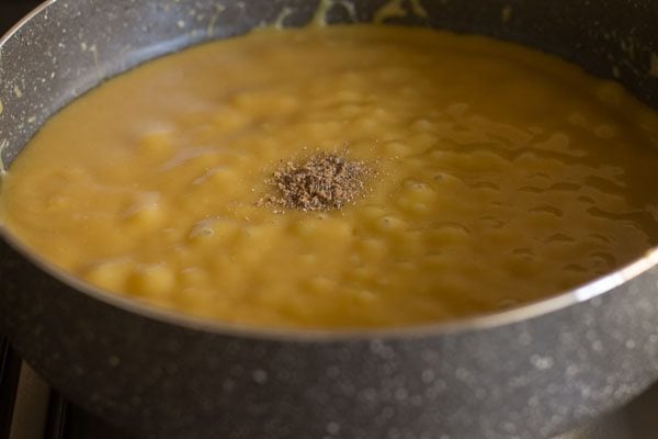 cardamom powder added to the bubbling mawa-sugar mixture. 