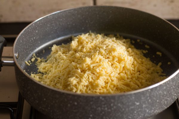 grated mawa added to a pan on low heat. 