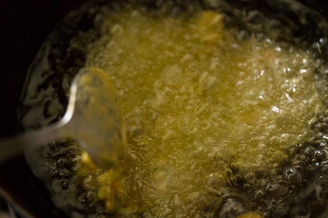 adding spoonful of batter in hot oil