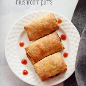 mushroom puff served on a white plate with dots of tomato sauce on the plate and text layover.