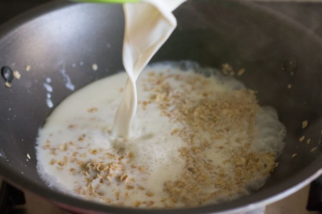 adding milk to oats.