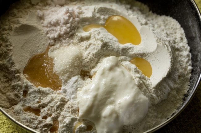 baking soda, curd, ghee, sugar and salt added to the flour mixture. 