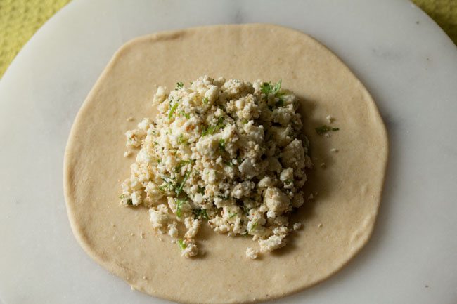 paneer stuffing placed in the center of the dough circle. 