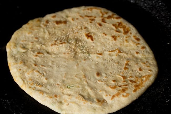 roasting paneer kulcha on a tawa. 