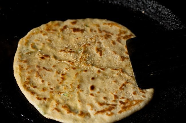 roasting paneer kulcha on a tawa. 