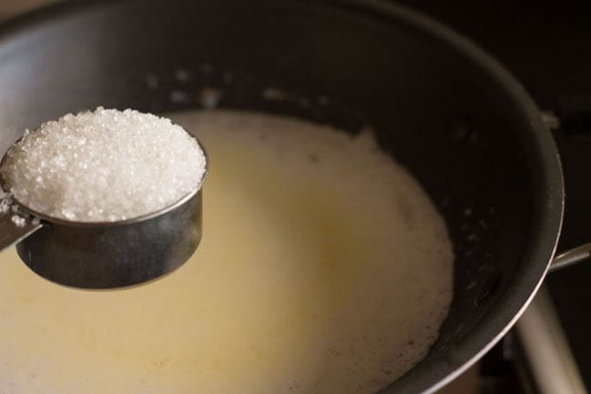 adding sugar in the kheer mixture. 