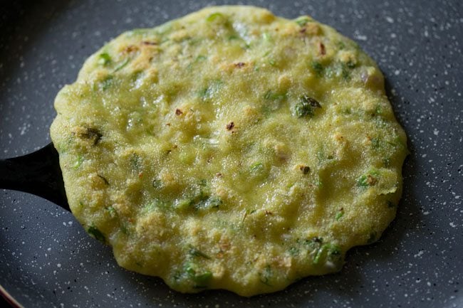 removing cooked suji ka cheela with a spatula. 