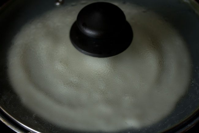 sabudana dosa covered with a lid and kept for cooking. 