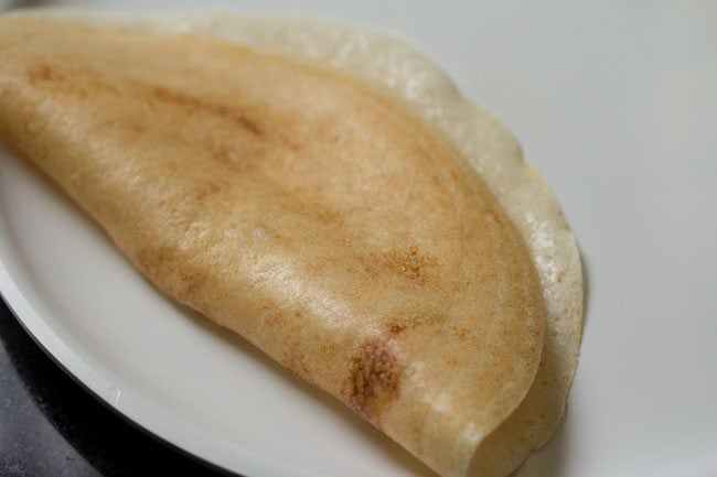 cooked sabudana dosa on a white plate. 