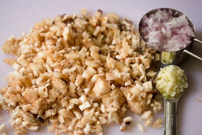 chopped mushroom stalks, chopped onion, and chopped garlic for making stuffed mushrooms filling. 