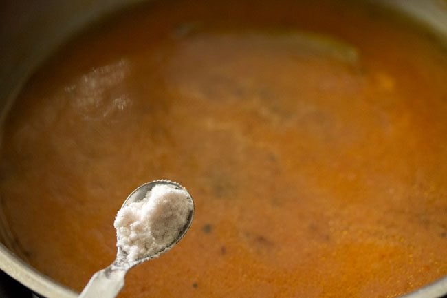 adding salt to the tomato shorba. 