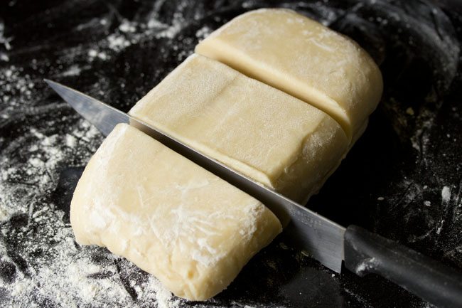 slicing rough puff pastry into thirds.