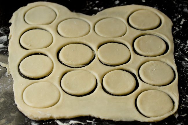 cutting out rounds of dough to make pizza puffs.