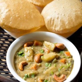 veg sagu garnished with chopped coriander leaves and fried cashews and served in a white bowl with pooris kept on a white plate at the background and text layover.