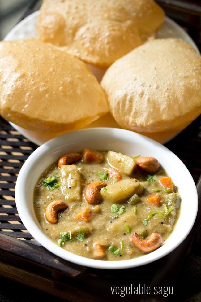 veg sagu garnished with chopped coriander leaves and fried cashews and served in a white bowl with pooris kept on a white plate at the background and text layover.