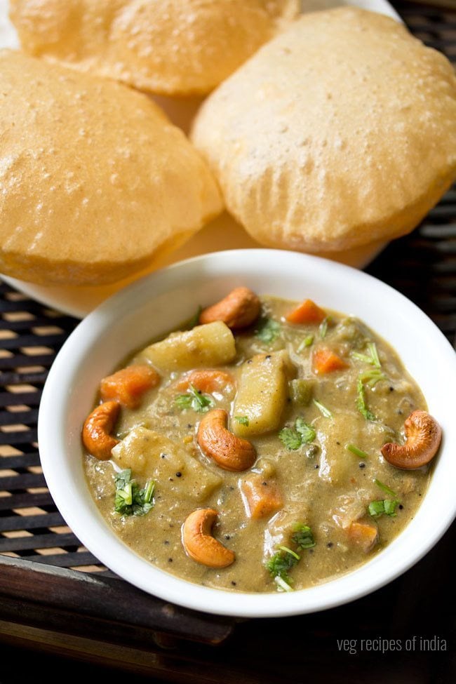 veg sagu garnished with chopped coriander leaves and fried cashews and served in a white bowl with pooris kept on a white plate at the background and text layover. 