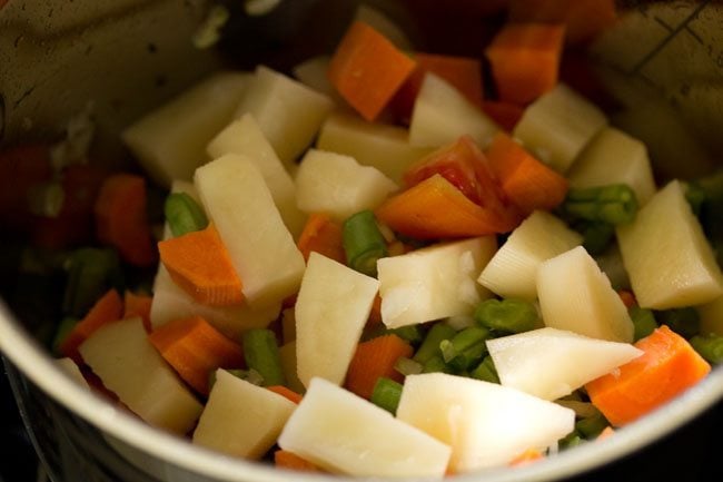 chopped mixed vegetables and tomatoes added to the pan. 