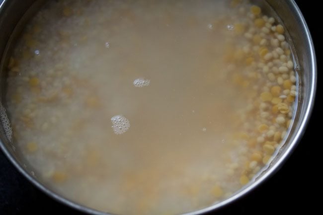 soaking rice and lentils in water for making vendhaya dosa. 