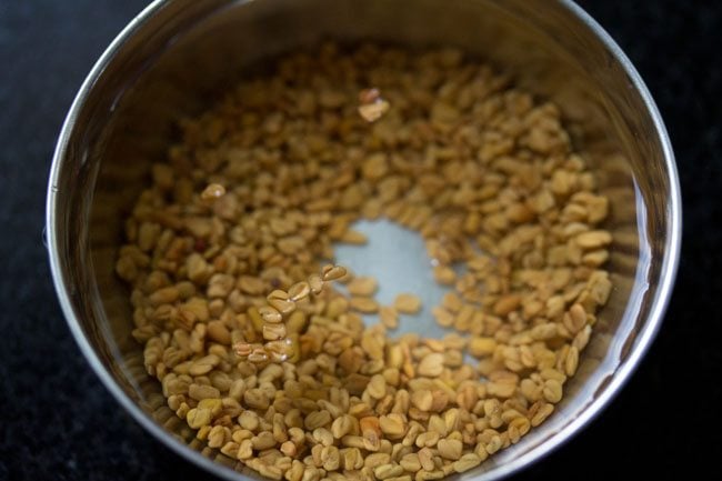 soaking methi seeds in water for making vendhaya dosa. 