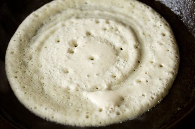 batter spread into a dosa on the hot pan. 