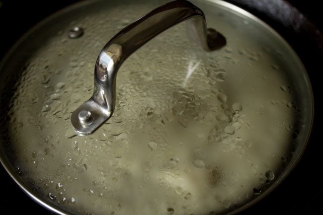 cooking methi dosa on the covered pan. 