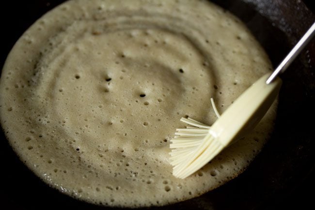 brushing the cooked top of the dosa with some oil. 