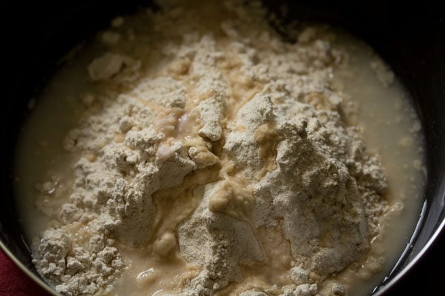 water added in parts to the flour for wheat momos recipe. 