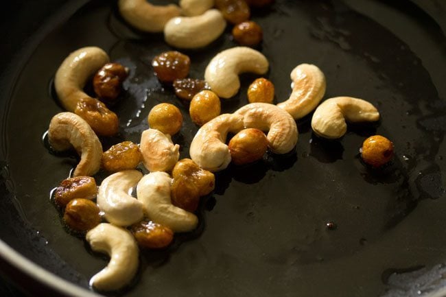 sautéing raisins till they puff up for making white pumpkin halwa. 