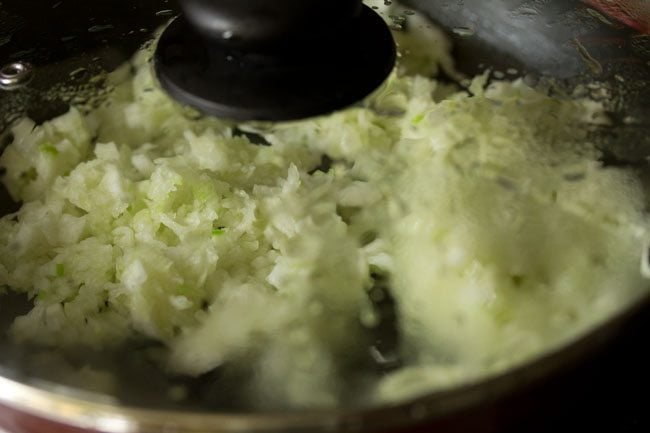 cooking ash gourd in a covered pan for making ash gourd halwa. 