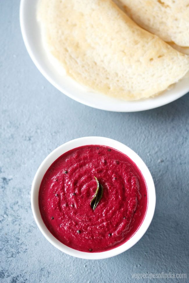 Beetroot chutney is served in a bowl with dosa on a plate