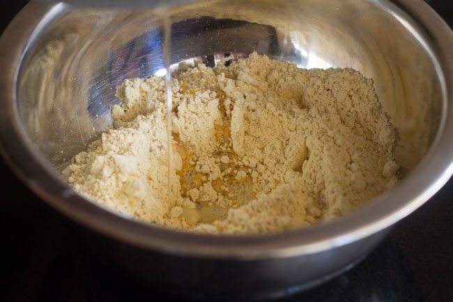 pouring hot oil into the depression made in the gram flour mixture.