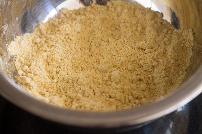 mixing hot oil in the gram flour mixture to achieve a breadcrumb like texture in the mixture.