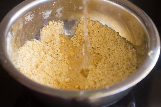 adding water in the gram flour mixture. 